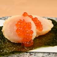 メニューは『天ぷら懐石』一本のみ。店主自ら市場で吟味した、旬の食材たちを懐石料理として堪能できます。写真は『ほたての天ぷら　いくら添え』。日本の春夏秋冬の恵みを、コースで満喫してみませんか。