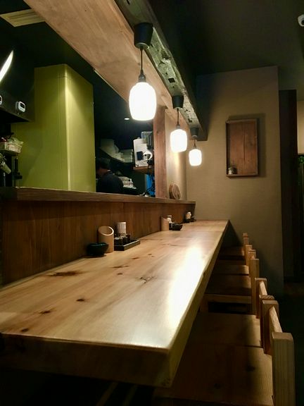 カウンター席に一人座り、香り高い焼鳥を楽しむ