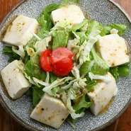 なめらかな豆腐とシャキッとした歯ごたえの葉野菜との、見事なコンビネーションを楽しめるサラダ。ドレッシングは風味豊かなゴマだれを使用しています。