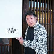 蒲　登志克（ガモ　トシカツ）氏
1974年、岐阜県生まれ。地元企業にて社長業を営む中、2018年頃に沖縄にある【燦別邸】を知る。自社の社員や家族、友人たちと足繁く通ううち、地元の多くの人々にその味を広めたいと考える。既に店の存在を伝えていた糸魚川氏と、店の立ち上げについて意気投合。2023年秋から店舗を探し始め、現在の場所と出合う。2024年4月、共同オーナーとして【燦別邸　岐阜店】を開店。