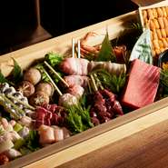 厳選された日本各地の新鮮な魚介類が、季節ごとのメニューを彩ります。例えば、バジル系のソースで味わう太刀魚の串。特に真夏には脂の乗りが高まり、より一層おいしさを感じることができます。
