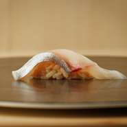 この一貫は、しまあじの腹部分の身を使用。脂が乗った部位なので、厚切りした1枚を豪快に楽しむ趣向。