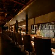 扉をあけるとそこには、重厚感溢れる15ｍものロングカウンター。カウンターの背には希少な国産ウイスキーが並び、奥には洋酒が圧巻の佇まいをみせます。約500本もの銘酒の、美しいラベルを眺めるのも愉しい時間。