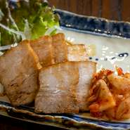 「幻の黒豚」といわれる奄美在来種の島黒豚を使い、時間をかけてじっくりと煮込まれた自家製チャーシュー。あっさりとした脂肪と、甘味のある赤身の旨みや食感を、キムチと共に味わえる人気の一品です。