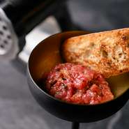 まずはゲストに黒毛和牛の塊肉を紹介し、その場で丁寧に挽いていきます。この一連のプロセスが食する人の期待感を高め、視覚的な楽しみも提供。挽いたばかりの美しい肉の質感と、鮮度をそのまま知ることができます。