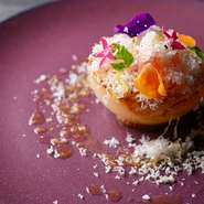 グランドメニューの一品として提供されています。蒸し焼きにした玉ねぎの甘さ、チーズと生ハムの塩気が見事に調和。エディブルフラワーで彩りを添えた、見た目にも美しい一皿です。