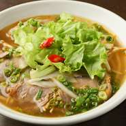 独特の辛みがある味付けで南部風にアレンジしており、少し甘めに仕上げています。牛骨スープに丸い米粉麺のブンを合わせて、牛肉、ベトナムハム、豚足、もやし、ネギなど具だくさんの一品。
大盛＋220円
