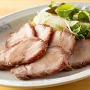 国産豚肩ロースを秘伝のレシピで焼き上げる【野毛横濱樓】の人気メニューです。しっとりやわらかな食感とジューシーな肉の旨みを楽しめ、格別の味わい。思わずお酒が進みます。