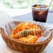 ジューシーな大きめサイズのポークフランクと、トマトソースを合わせたフォカッチャ。【ベーカリーカフェフラミンゴ】のメニューでも、特にボリューム感がある逸品です。生地のモチモチ食感もクセになります。