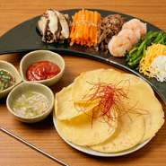 数種類のナムルをピン（小麦粉の皮）に包んで食べるヘルシーなのに満腹感のある一品！