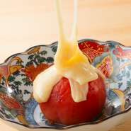 炭火でまるごと焼き上げたトマトにたっぷりのチーズソースをかけたさっぱりコクのある一品です。