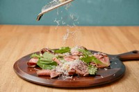 チーズもたっっぷりかけちゃいます！薄切りした牛タンのローストビーフをトリュフ醤油ダレと削りたてパルミジャーノで絶品！