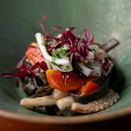 イカスミを練り込んだ自家製の手打ち生パスタが、海の豊かな風味を引き立てています。パスタの上にはレモンマリネした甲イカをのせ、爽やかさと旨みをプラス。見た目の美しさも魅力です。