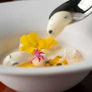 手づくりジェラートとアーモンド風味のプリンを組み合わせたデザートです。爽やかなパッションフルーツがアクセント。メレンゲの焼き菓子をトッピングし、豊かな食感と風味のコントラストを演出しています。