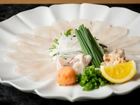 25年以上、ふぐ調理師としても活躍する料理長が極上のふぐ料理を披露。今の店の開業前に、大分県臼杵の老舗ふぐ料亭【山田屋】での修業も経験し、味わいと趣向がさらに進化。写真は優美な盛付けも評判の『てっさ』。