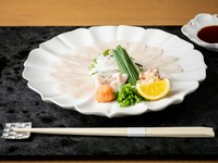 大分県臼杵産を中心とする最上質なふぐは、旨みを最大限引き出すため、時季によっては熟成させることも。素材に応じた包丁技で仕上げるお造りは、あえて白磁の器に盛付け、おいしさと共に繊細で優美な世界観を披露。