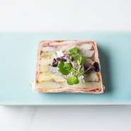 カマスと里芋をミルフィーユ状に重ねて焼き上げた前菜。ベーコンの薫香とトリュフのクリームの組み合わせの妙が味わえます。層を重ねた美しい見た目と共に、食べるごとに異なる味わいに驚くはずです。