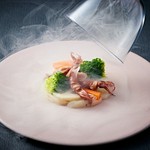 旬の訪れを告げるホタルイカと、甘みあふれる帆立貝柱を、スモークの芳醇な香りで包み込みました。香り高い一皿をご堪能ください。