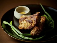 骨付き豚肉をアジアの香草で漬け込みジューシーに焼き上げたシェフおすすめの料理。食べ応えも十分で大阪産難波ネギと共にお召し上がりください。