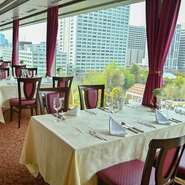 日比谷公園の豊かな緑とビル群が建ち並ぶ近代的な風景を一望できる、窓際の席。ランチタイムは開放的に、ディナータイムは煌びやかに。ここに座れば、景色も一つのごちそうとなります。