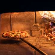 店内で存在感を放つ薪窯。ピッツァメニューは、その薪窯を使い、火加減を調整し、高温で一気に焼き上げます。表面はカリッと、中はモチモチとした食感のピッツァを楽しめます。