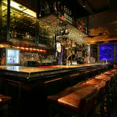 ラグジュアリーなバーカウンターで、横並びに座る大人デートを