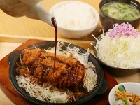 熱々の鉄板にのせられた揚げたてのとんかつに、赤みそだれをかけていただく『名物　鉄板みそかつ定食』。名古屋で愛される本場の味を、【とんかつ玉藤】流にアレンジしてあります。くせになるおいしさをぜひ！
