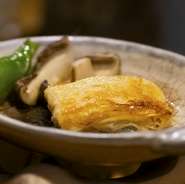 コース内の一品。バターの風味香ばしい ゆばの陶板焼きは、ふっくらと一番の食べ頃に目の前でスタッフがお焼き致します。＊コースにより内容が異なります。