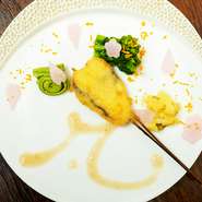コース料理の中で提供される目にも華やかな一皿です。うららかな春のある日は、サワラの串揚げをメインに菜の花・こごみ・筍などの春野菜を添えて。桜風味のソースが素材の味をいっそう引き立てます。