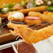 素材の食感を十分楽しんでほしいという思いから、衣の厚さはわずか1mm以内。カラッとあっさり、サクッと揚げられた海老は絶品です。レモンとこだわりの塩でいただきます。