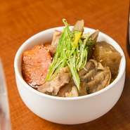 串打ち時に出る端材を活用した『みんぶた名物　肉煮込み』は、売り切れ御免の人気メニュー。鶏もも肉をベースに豚もつの旨みを加え、にんにくを効かせたあっさり醤油味がたまりません。
