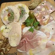 アマニ配合の飼料で育った「アマニ豚」を使ったロースハム、リエット、パテ・ド・カンパーニュ、鶏レバーのパテ、砂肝のコンフィなど店内仕込みの逸品や生ハムから、シェフおまかせの５品の盛り合わせ。