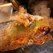 テーブルでは焼き上げまでを自分たちの手で仕上げることも。基本的に麺が入っていないお好み焼きは、ゲスト自身の手で焼き上げまで楽しめます。キレイに焼く自信のない方は、スタッフにお願いもできるのでご安心を。