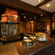 店内の中央に据えられた焼き場、湯気を豪快に上げながら白飯を炊き上げる釜戸など、臨場感もまた同店の魅力です。庭園を臨めるテーブル席のほかキッズルームなどもあり、一つ一つがゆったりと設えられた和空間。