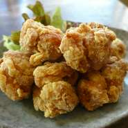 【おが屋】の、おつまみ人気不動のNo.1、揚げたてサクサクの『鶏の唐揚げ』に自家製甘酢醤油をジュワッとかけます。口いっぱいに広がるアツアツの肉汁がたまらないおいしさ。「しあわせ」な気持ちになれる逸品です。