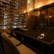 店内は、シャンデリアが輝くラグジュアリーな空間です。カウンター席のほか、個室も多数用意。ブラックのテーブルとソファが重厚な雰囲気を醸し出し、ナチュラルな木の床やダウンライトが温かな雰囲気を加えます。