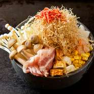 月島本店で愛される看板もんじゃ。豚バラ・エビ・イカ・しめじ・エノキ・コーン・ちくわ・ツナ・きりいか・桜えびの10種類が織り成すハーモニーを楽しめます。