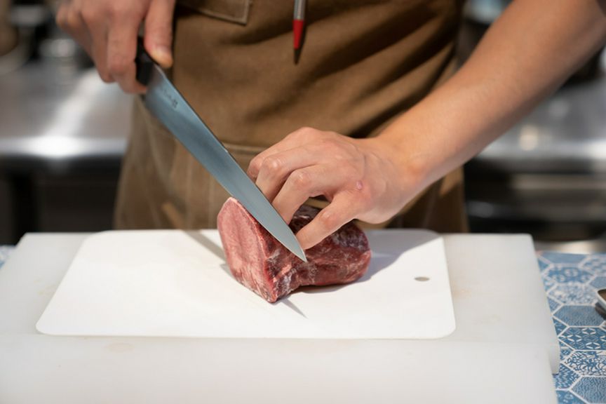 料理人が、塊肉から手切りする姿を見られるカウンター席