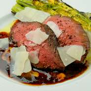 低温でじっくり火入れを行うことで、「なにわ黒牛」の旨みをギュッと閉じ込めています。牛骨からつくった濃厚なトリュフソースが美味。最後に旬菜を添え、チーズを削れば完成です。