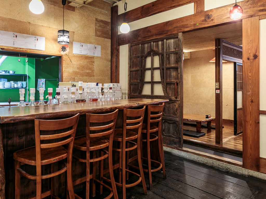 仕事帰りの一人飲みを楽しむ。木目調のカウンター席