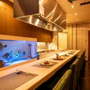 カウンターを主体に洗練された佇まいをみせる店内。料理人による鮮やかな職人技や、生け簀を悠々と泳ぐ魚たちを眺めつつ、贅沢な一時に没頭できます。