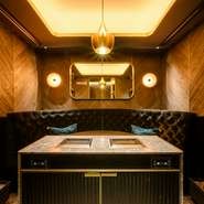 店内は黒を基調としたモダンでラグジュアリーな雰囲気。食事を楽しむテーブルとは別に専用の特注グリルが設えられており、常駐している専属の焼き師が一枚ずつ丁寧に仕上げています。