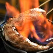 【焼肉とどろき】オリジナルのステーキカット肉を、熟練したスタッフがテーブル席でフランベします。炎をまとう瞬間に感動。フランベに使うリンゴの洋酒がお肉を香り高く仕上げます。