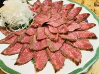 九州産黒毛和牛の赤身肉（主にもも肉）を、絶妙な火入れでたたきとして提供。お酒と楽しみたい逸品です。