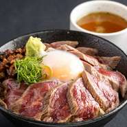 自社牧場で育てたあか牛を贅沢に使用した、その旨みを手軽に味わえる丼ぶりです。ミディアムレアに焼かれたあか牛ステーキのスライスが、ご飯の上に贅沢に敷き詰められています。
