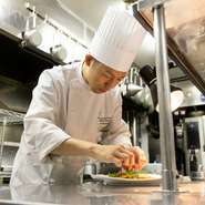 会場のすぐ隣のキッチンで、お客様の笑顔がこぼれる瞬間を思い浮かべつつ、一品一品と向き合うシェフ。“熱いものは熱いうちに”と、基本の大切さを忘れずに、常にゲストを想い、料理を提供しています。