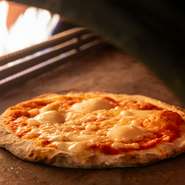 生地からつくる自慢の窯焼きピザ。オーダーを受けてから店内の窯で焼き上げます。窯の温度は400℃。高温で一気に焼き上げるので、中はもっちり外はさっくり仕上がります。