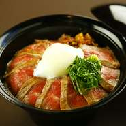 自社牧場で育てたあか牛を贅沢に使用した、その旨みを手軽に味わえる丼ぶりです。ミディアムレアに焼かれたあか牛ステーキのスライスが、ご飯の上に贅沢に敷き詰められています。