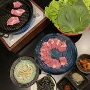 ジンギスカンと同じく焼いたラム肉をいただくものですが、味付けが全く異なるためハマる人が多いそう。サンチュにラム肉とネギやパクチー、キムチを挟んで味わいます。まろやかな甘みのある韓国味噌が味の決め手。