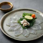 透き通った美しさに目を奪われる一皿。熟練の技で捌くとらふぐを熟成させた後、昆布締めしています。